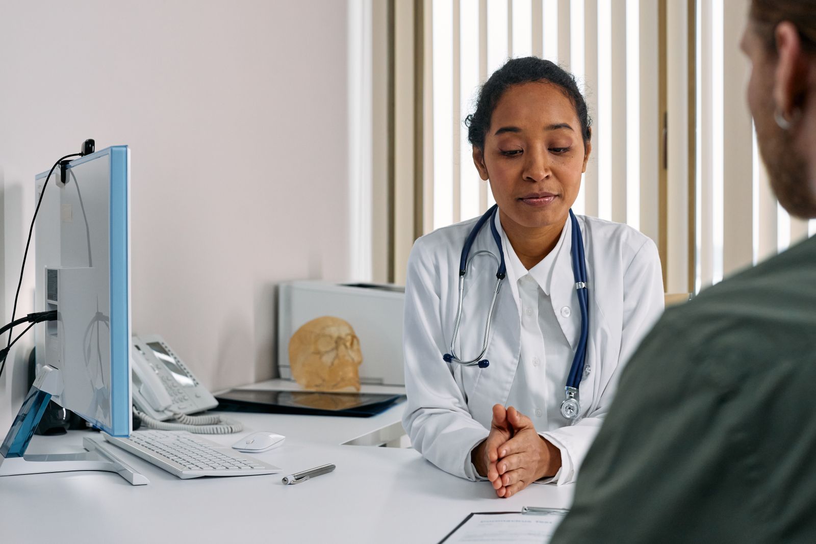Une médecin écoute un patient en consultation