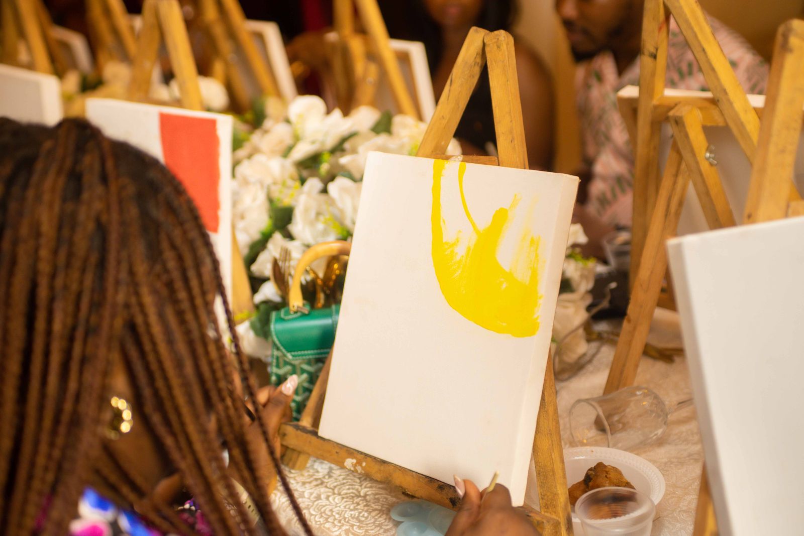 Des participants peignent sur chevalet lors d'un atelier collectif