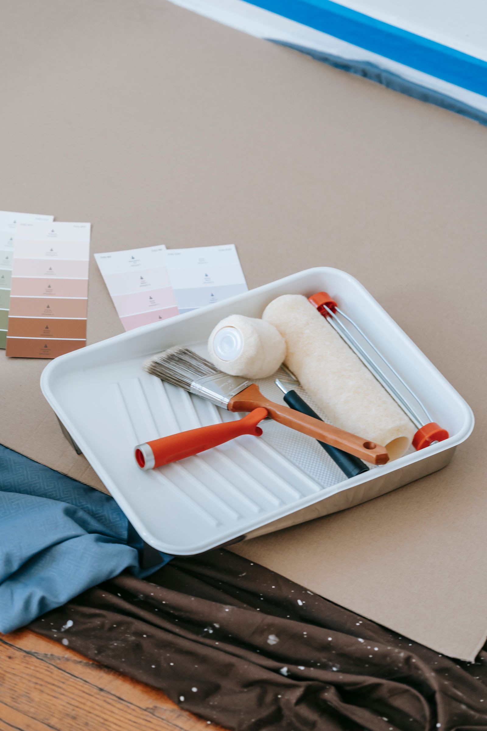 Rouleau, pinceau et nuancier de peinture préparés pour des travaux de rénovation