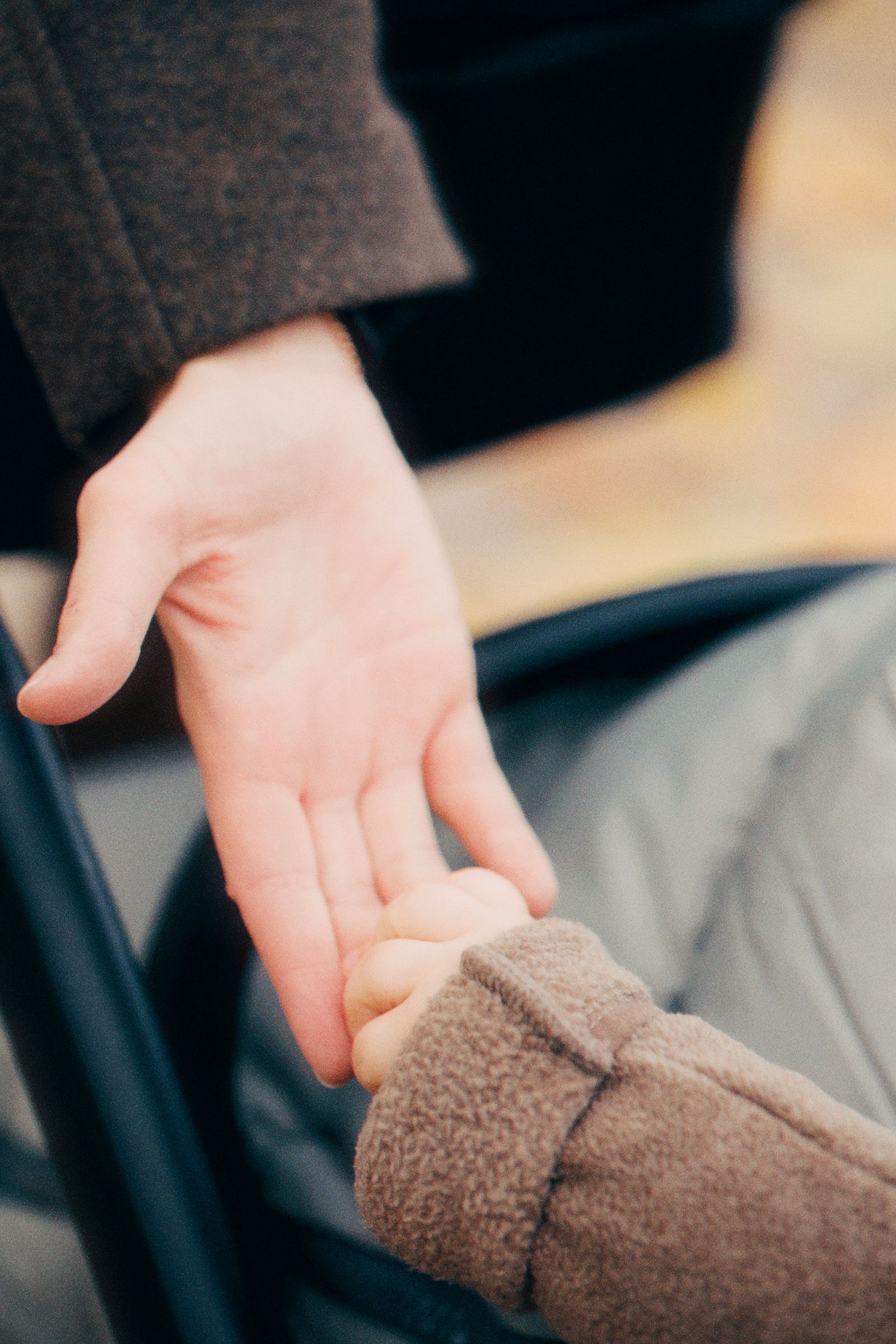 La main d'un enfant posée dans celle d'un adulte